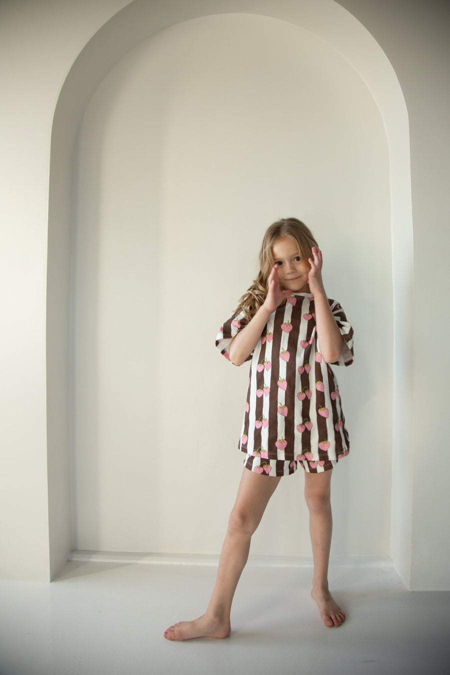 Child wearing the Berry Stripe Set — strawberry stripe tee and matching shorts